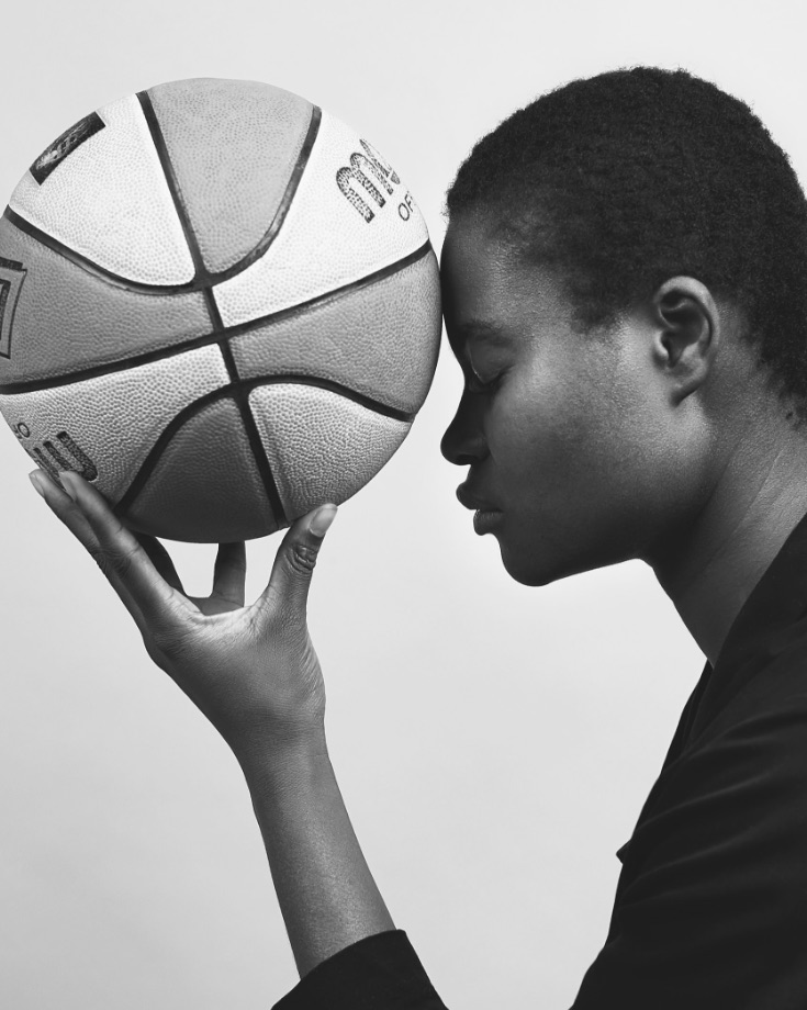 frau hält basketball an stirn