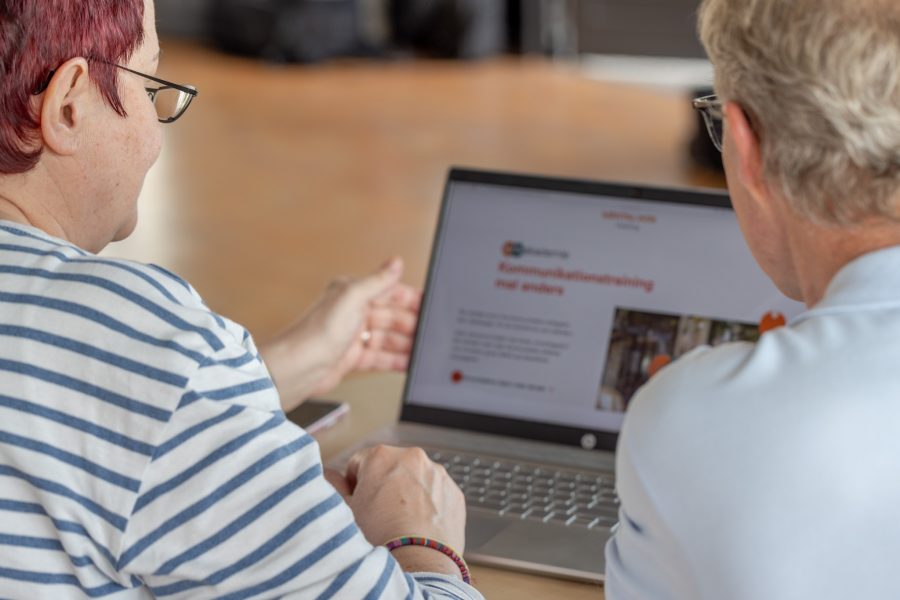 Eine Frau, ein Mann schauen sich eine Internetseite im Laptop an